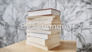Im Hintergrund ein Stapel Bücher auf einem Holztisch. Im Vordergrund ein Schriftzug in Weiß mit schwarzer Umrandung. Der Schriftzug lautet: „Beziehungen“ und verweist auf die Kategorie der Leseempfehlungen.